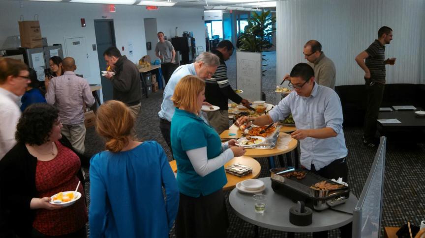Coworkers enjoying the cooking of Chef Cheung at our welcome to 101 Potluck.